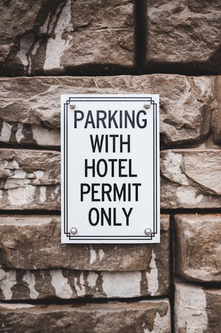 A reserved parking sign indicating it is designated for disabled access and van parking, mounted on a metal pole against a background of leafless tree branches and an overcast sky. The sign features a blue and white wheelchair symbol with the words 'RESERVED PARKING' at the top and 'VAN ACCESSIBLE' at the bottom. This type of signage is commonly used in residential areas, such as Newbury Park, to reserve parking spaces for moving vans or accessible vehicles during home relocation or furniture transport activities. The image relates to the process of arranging parking permits for Newbury Park movers, such as those provided by Man with Van Newbury Park, to facilitate smooth home removals and packing and moving services in the area.