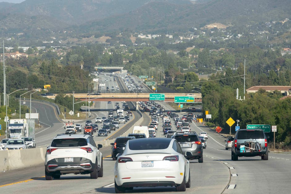 A multi-lane motorway with heavy traffic congestion visible as numerous cars and vans traveling in both directions, with some vehicles including a white van positioned on the right side of the road ne